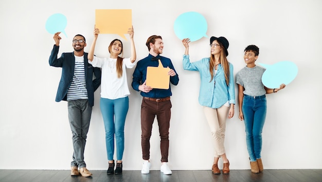 Foto queremos compartir nuestros pensamientos foto de un grupo diverso de empleados creativos sosteniendo globos de diálogo en el interior