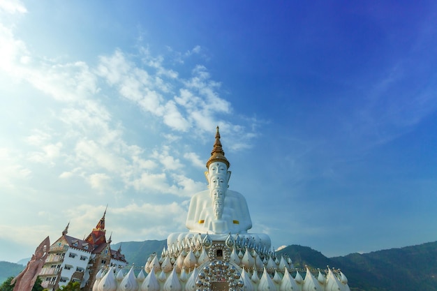 Querformat der großen weißen Buddha-Statue im Tempel Wat Phra That Pha Son Kaew mit Blick auf die Berge
