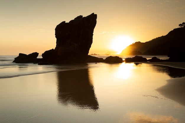 Foto querformat von einem wunderschönen sonnenaufgang am strand von aguilar muros de nalon asturien spanien