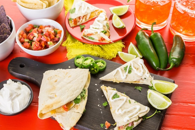 Quesadilla fatiada com recheio de queijo, frango e pico de gallo.