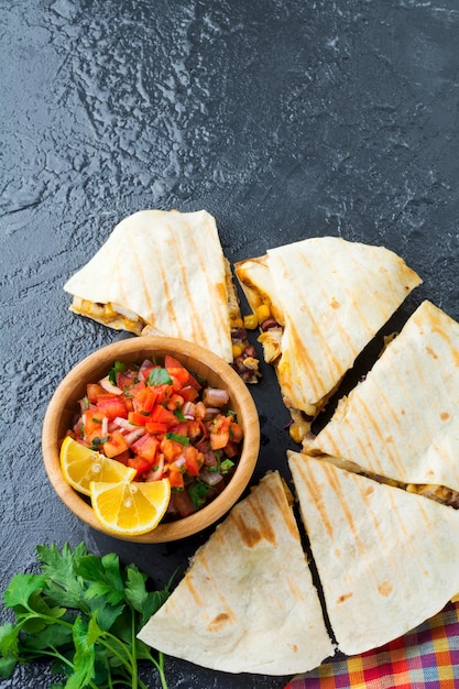 Quesadilla mexicana com frango, milho, feijão vermelho, queijo e pimentão e salsa. Foco seletivo. Vista superior.