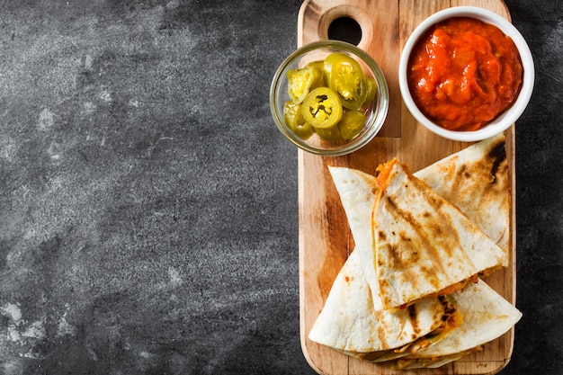 Quesadilla mexicana com frango, queijo e pimentos em fundo preto