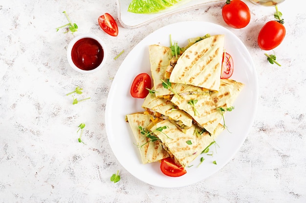 Foto quesadilla mexicana envuelta con maíz de pollo y pimienta dulce en un plato blanco vista superior