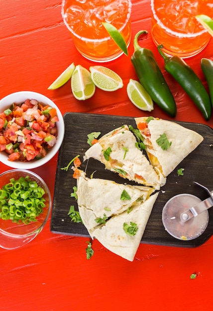 Quesadilla rebanada rellena de queso, pollo y pico de gallo.