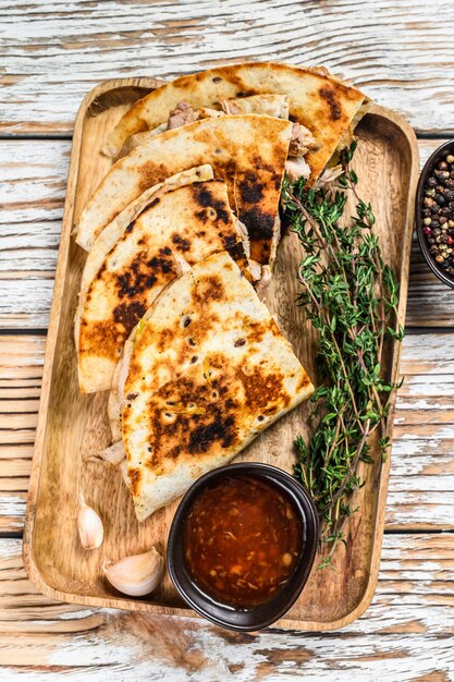 Quesadilla de snacks vegetarianos con verduras y queso en bandeja de madera.