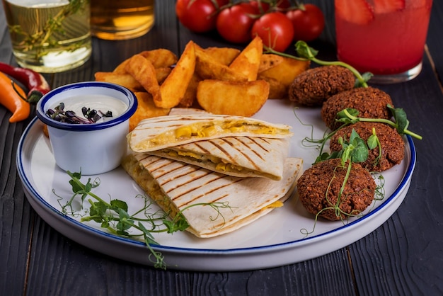 Quesadillas grelhadas com falafel em fundo preto de madeira