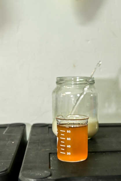 Foto quesero toma con el tubo de ensayo de la mano con la cuajada para la producción de queso en la lechería