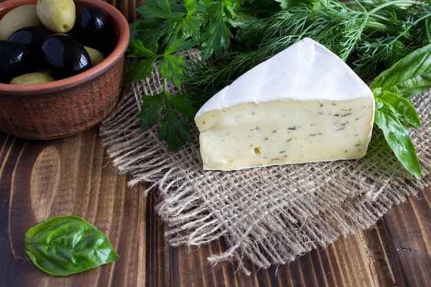 Queso y aceitunas en el fondo de madera