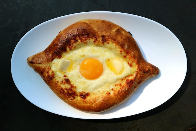 Queso Adjarian Khachapuri y pan georgiano tradicional relleno de huevo fresco