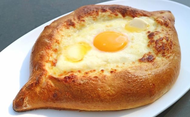 Queso Adjarian Khachapuri recién horneado y pan tradicional georgiano relleno de huevo