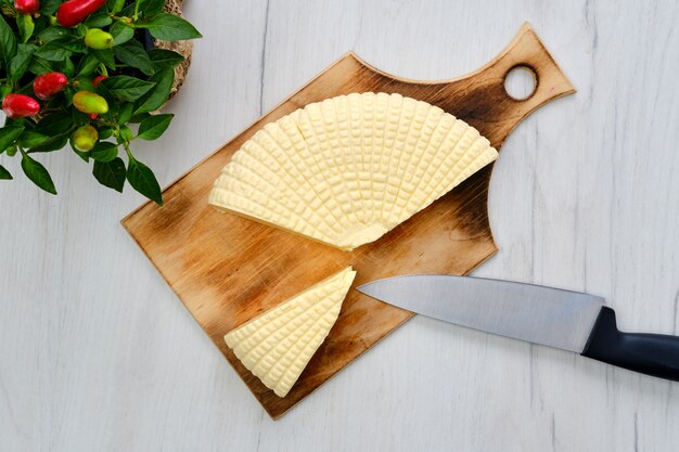 Foto queso adyghe fresco sobre tabla para cortar madera