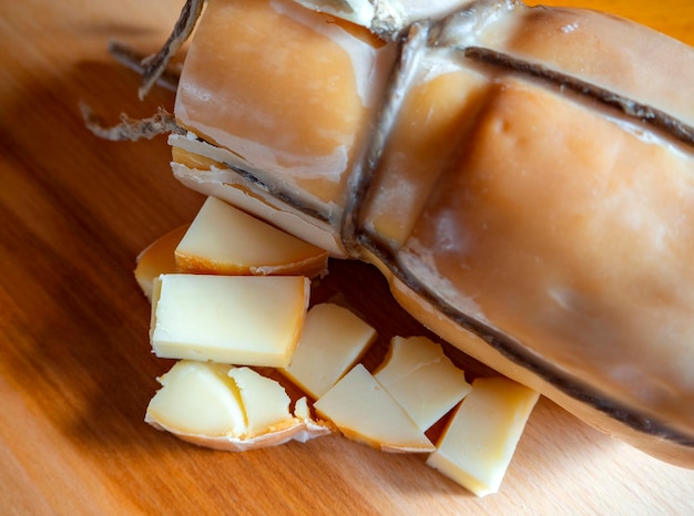 Queso ahumado griego tradicional Metsovone en una tabla de madera del pueblo Metsovo en Grecia