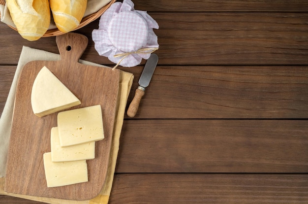 Queso artesanal de Alagoa de Minas Gerais Brasil sobre una tabla de madera con mermelada de pan y espacio para copiar