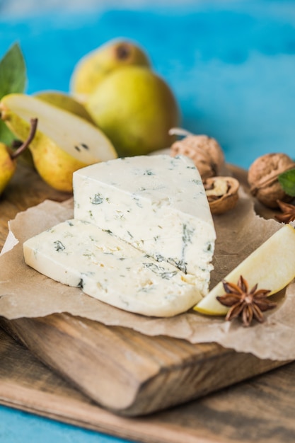 Queso azul italiano gorgonzola picant, elaborado con leche de vaca sin desnatar en el norte de Italia. Trozo de queso de moho azul danablu, roquefort con pera y nueces