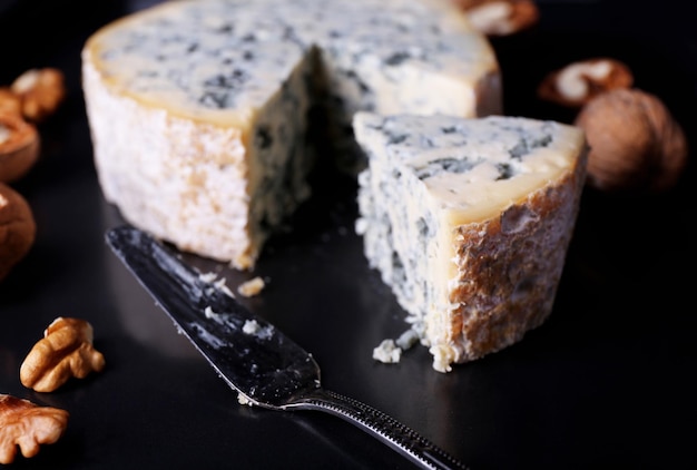 Queso azul con nueces y hoja sobre fondo de bandeja de metal