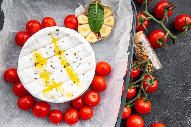 Queso Brie al horno o Camembert con tomate, ajo y hierbas comida saludable comida snack en la mesa