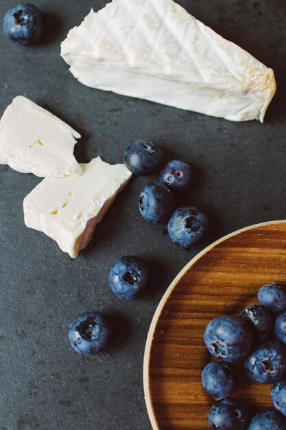 Queso brie con moho y arándanos en la mesa