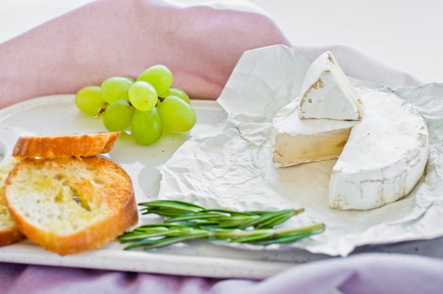 Queso brie con nueces sobre una tabla de cortar blanca