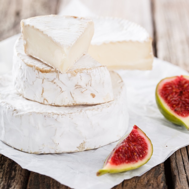 Queso brie sobre una tabla de madera con higos frescos.