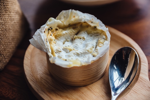 Queso brie sobre tabla de madera.