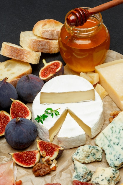 Queso Brie en una tabla de madera con higos frescos y miel