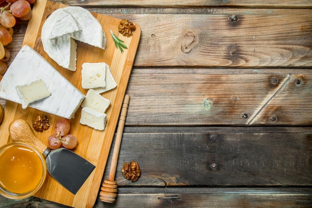 Foto queso brie con uvas nueces y miel en la junta