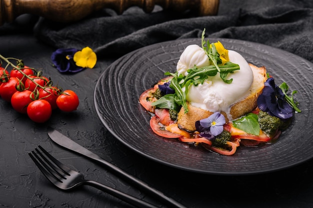 Queso burrata de búfala servido con pasta de tostadas de cereales y verduras frescas