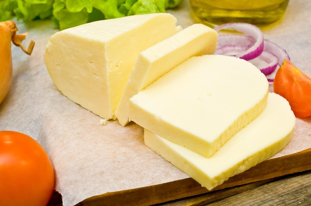 queso de cabra suave en un bol sobre una mesa de madera con verduras