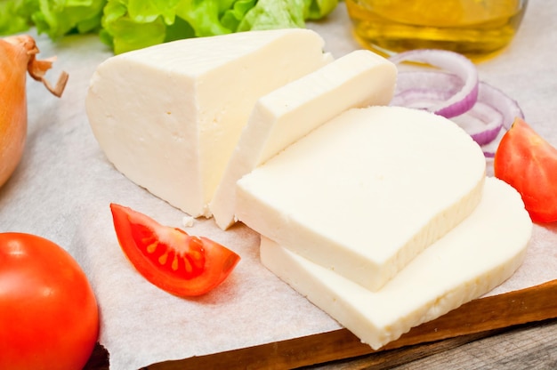 queso de cabra suave en un bol sobre una mesa de madera con verduras