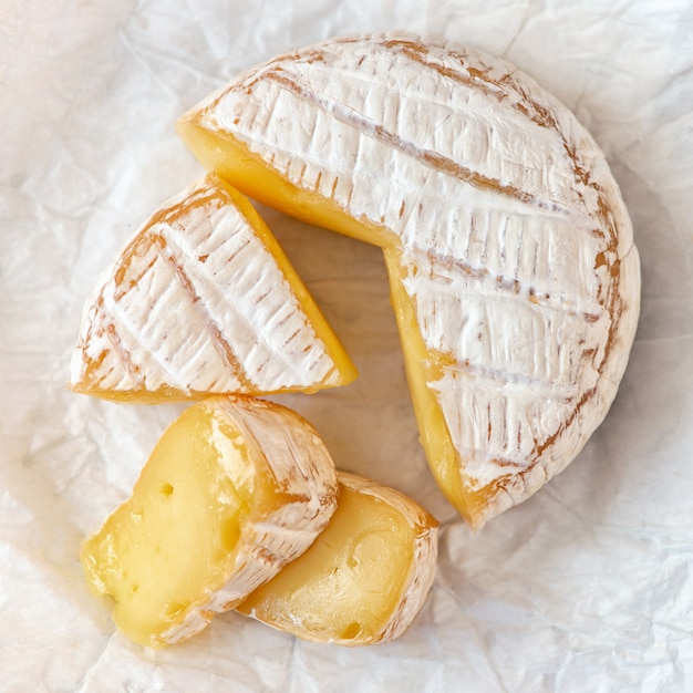 Un queso Camembert madurado suave en blanco.