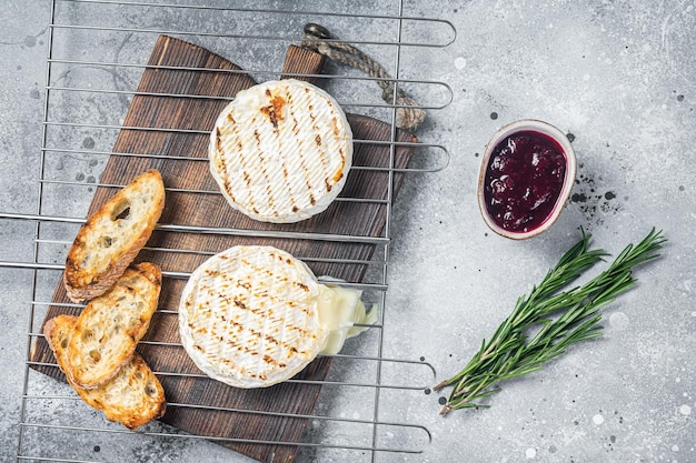 Queso camembert a la parrilla con salsa de arándanos y tostadas Fondo gris Vista superior