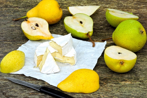 Queso Camembert con peras sobre una superficie de madera.