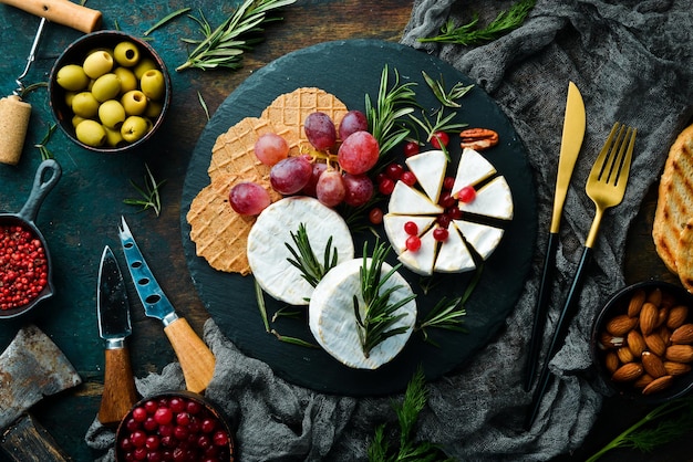 queso camembert Queso brie con arándanos y snacks. Estilo rústico. Espacio de copia libre.