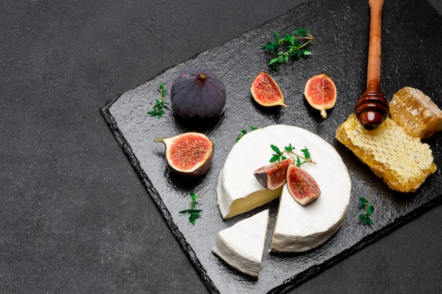 Queso Camembert y una rodaja cortada en piedra para servir