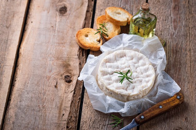 Queso camembert con romero sobre fondo de madera