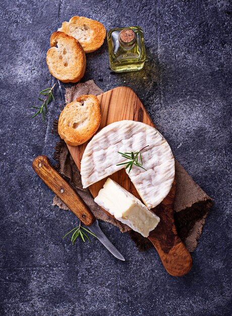 Queso camembert con romero sobre tabla de madera