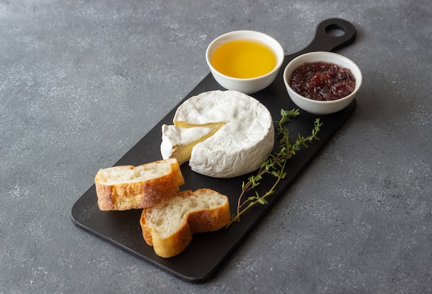 Queso camembert con tostadas, miel y mermelada. Bocadillo de vino.