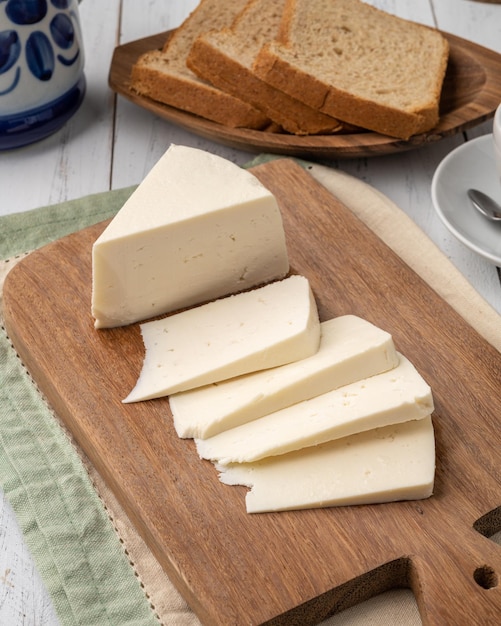 Queso Canastra fresco artesanal con pan sobre tabla de madera