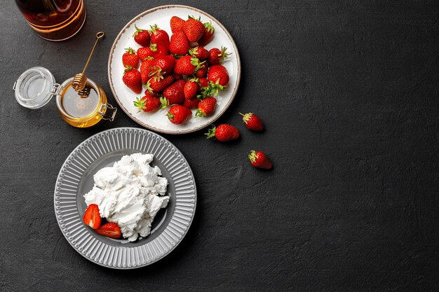 Queso crema y fresas frescas sobre negro de cerca