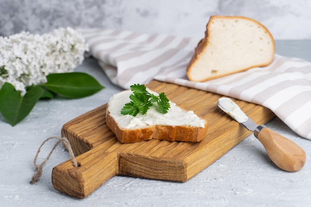 Queso crema con hierbas y condimentos en rebanadas de pan de centeno crujiente fresco con cuchillo de queso cerca