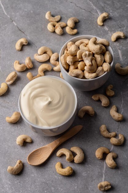 Queso crema de nuez de anacardo en un plato blanco sobre un fondo de piedra de mármol gris