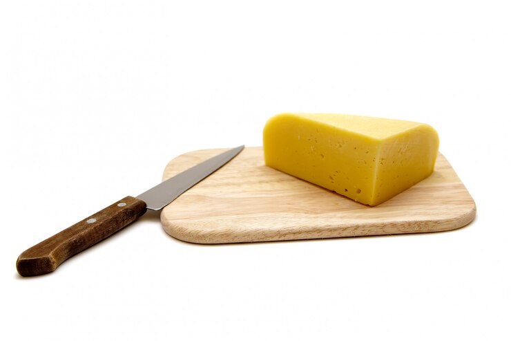 Queso y cuchillo en una tabla de cortar