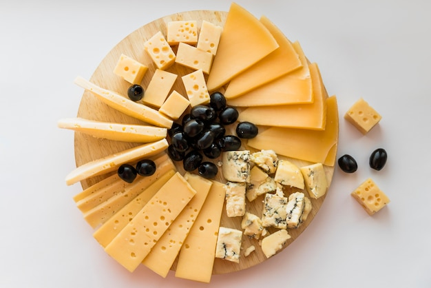 Foto queso fresco y aceitunas en tabla de cortar de madera