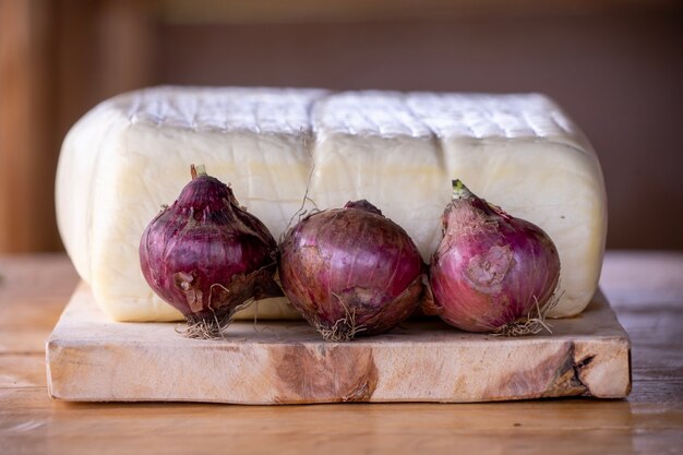 Un queso fresco grande con hierbas y cebollas.