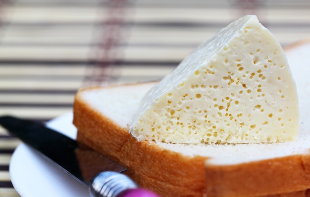 Queso fresco con pan en una placa blanca.