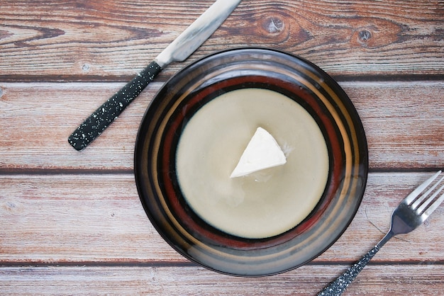 Queso fresco en un plato sobre fondo de madera