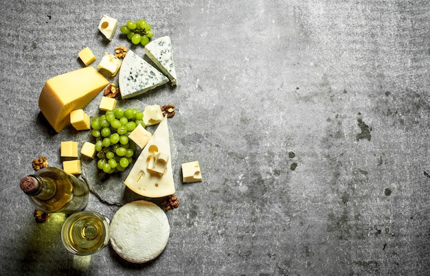 Queso fresco con uvas y vino blanco. Sobre la mesa de piedra.