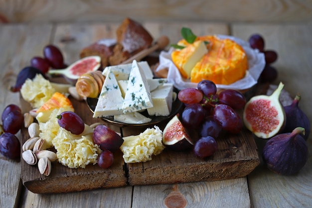 Queso con frutas sobre una tabla de madera