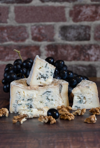 Queso gorgonzola de moho azul con uvas y nueces. Hecho a mano.