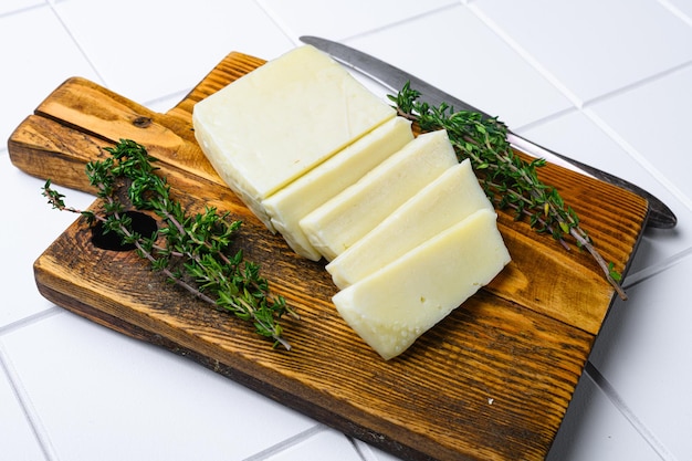 Foto queso halloumi de chipre sobre fondo de mesa de baldosas cuadradas de cerámica blanca